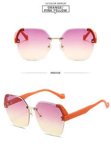 Detail view of rimless gradient lenses in orange-pink with textured gold temples
