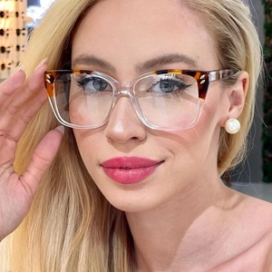 Close-up of cat-eye glasses featuring tortoise shell upper frame and transparent lower rim