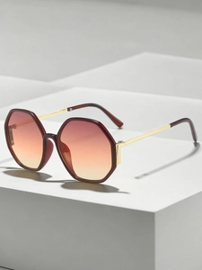 Detail view of hexagonal sunglasses with orange gradient lenses on white geometric props