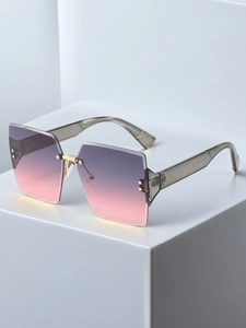 Detailed view of square rimless gradient lenses and gold metal bridge on sunglasses