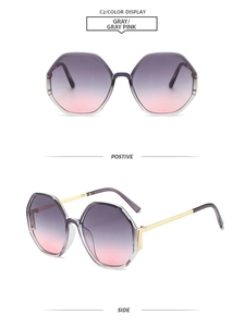 Close-up of hexagonal sunglasses with grey-pink gradient lenses and gold metal temples