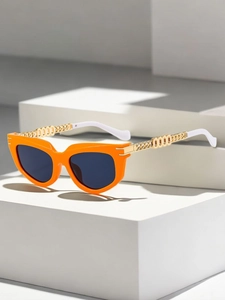 Detail of orange cat eye sunglasses featuring gold chain temples and black lenses