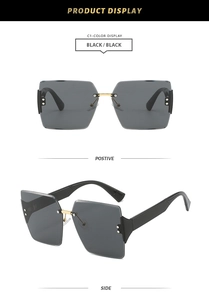Detailed view of frameless black sunglasses with gold metal bridge and side rivet decor