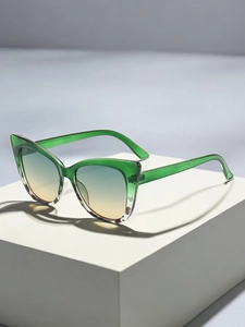 Detail view of cat-eye sunglasses with green frame and orange gradient lenses