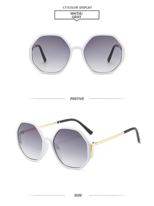 Macro view of white hexagonal sunglasses with gradient gray lenses and gold metal temples