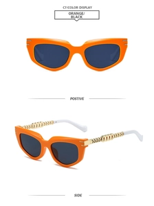 Detail of square cat-eye sunglasses with orange frames and gold chain temples