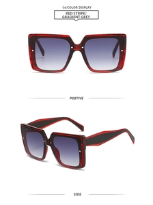 Detail view of square frame sunglasses in red stripe pattern with gradient grey lenses