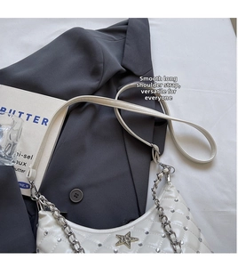 Détail du sac blanc matelassé à chaîne avec breloque étoile et clous métalliques