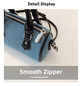 Detail of smooth silver zipper and denim texture on mini pillow bag with leather handle