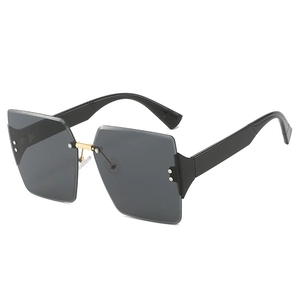 Fashionable square rimless sunglasses with black lenses and gold metal nose bridge accents