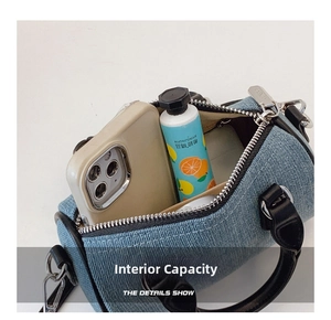Internal capacity of denim pillow bag showing space for phone and hand cream