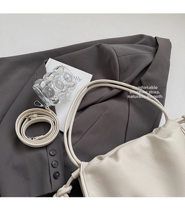 Close-up of off-white ruched leather bag with detachable strap and荔枝 texture