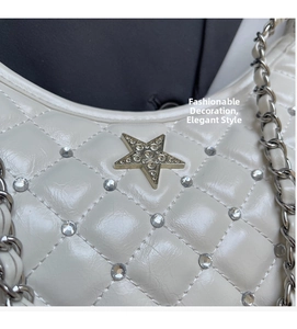 Détail du sac matelassé blanc cassé avec logo étoile en strass et bandoulière chaîne