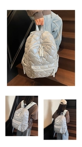 Close-up of quilted light blue backpack with diamond stitching and woven zipper pullers