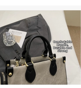 Détail du sac cabas bicolore élégant avec poignées en cuir noir et finitions en métal doré