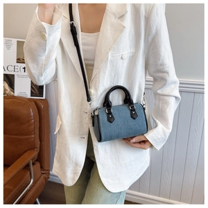 Blue denim mini pillow bag worn as a shoulder bag with white blazer outfit