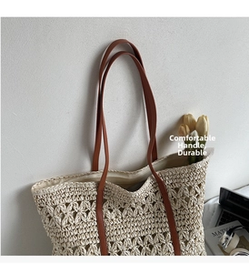 Detailed close-up of hollow straw tote bag featuring brown leather handles and tulip decor