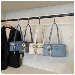 Denim underarm bags in four colors with heart charms and stripe ribbons on display