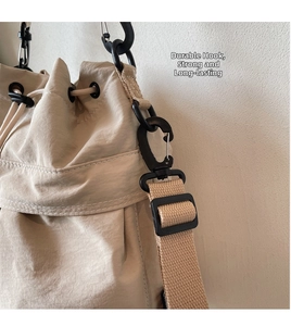 Close-up of beige nylon bucket bag featuring durable black hooks and woven strap details