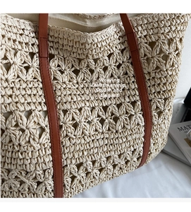 Detailed view of hollow star-patterned straw weave and brown leather handles on tote bag