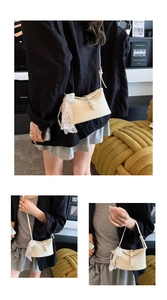 Détail du sac bandoulière tressé avec breloque perle et boucle métallique réglable sur le côté