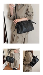 Detailed close-up of black pleated cloud bag with stylish knot strap and leather texture