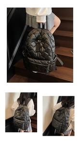 Detail of black quilted padded backpack with smooth dual zippers and spacious front pocket