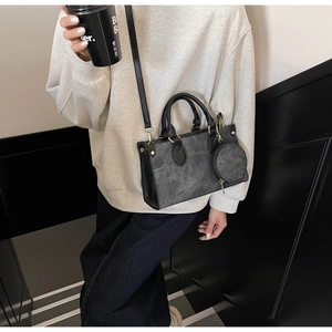 Détail du sac cabas gris en similicuir avec mini pochette ronde et détails dorés sur modèle
