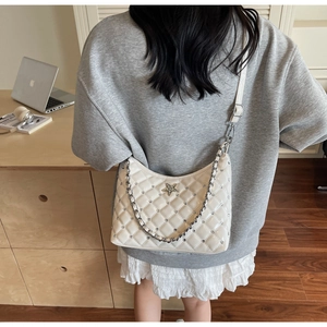 Détail du sac à bandoulière matelassé crème avec étoile en strass et chaîne en métal