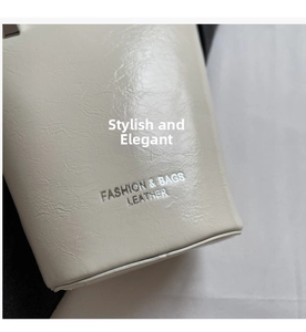 Close-up of creamy white leather bucket bag texture with silver embossed logo detail