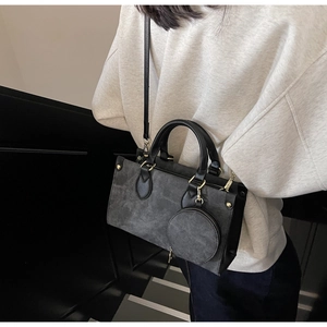 Detail of grey suede-texture tote bag with small round coin purse and gold hardware