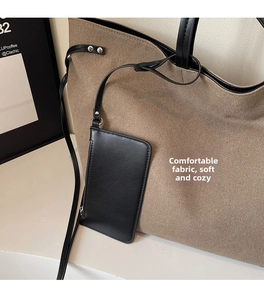 Detail of khaki canvas tote bag with a black leather zipper pouch and silver hardware