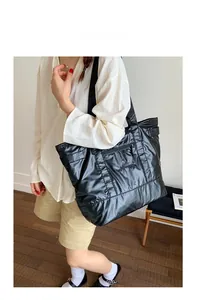 Détail du sac cabas matelassé noir avec poche zippée et texture en nylon souple
