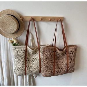 Detail of hollow straw tote bag with faux leather straps for summer beach vacation