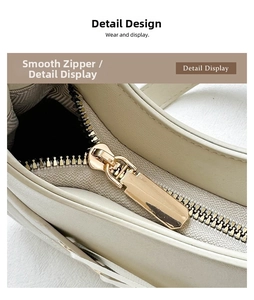 Detailed close-up of smooth light gold zipper hardware on creamy white leather shoulder bag