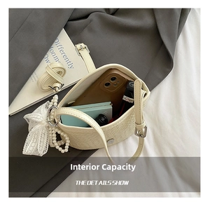 Détail de l'intérieur du sac seau tressé montrant l'espace pour téléphone et maquillage