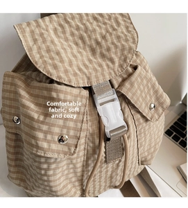 Detailansicht eines khakifarbenen Canvas-Rucksacks mit Kordelzug und Kunststoffschnalle