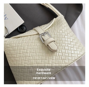 Gros plan détaillé du sac seau tressé crème avec boucle argentée et texture cuir