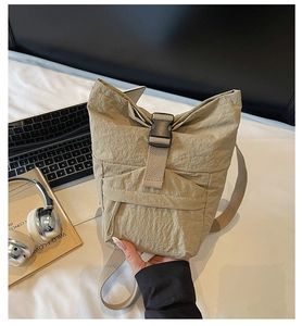 Detalle del bolso de nylon caqui con cierre de hebilla y bolsillo frontal ajustable