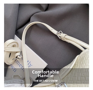 Détail de la bandoulière réglable en cuir tressé avec boucle argentée sur le sac crème