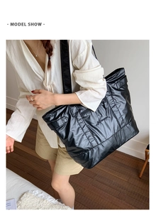 Gros plan d'un grand sac cabas noir matelassé avec logo pour les déplacements quotidiens