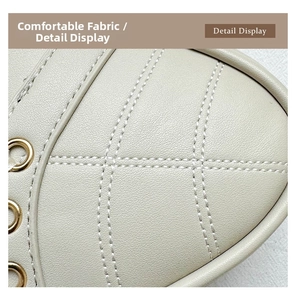 Detail of cream leather shoulder bag with quilted diamond pattern and gold metal eyelets