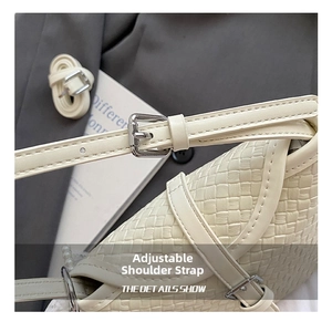 Détail de la bandoulière réglable en cuir et boucle en métal argenté du sac tressé