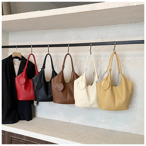Litchi pattern leather tote bags in five colors hanging on a minimalist display