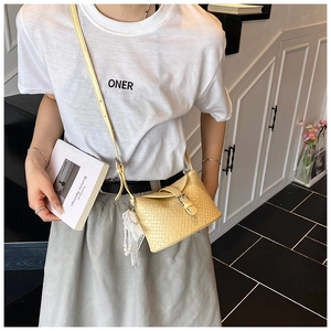 Détail du sac seau tissé avec élégante chaîne en perles et ornements en dentelle