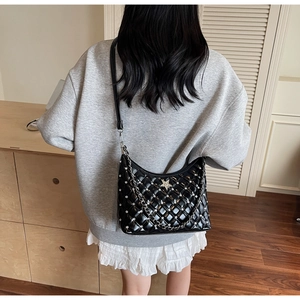 Détail du sac à bandoulière matelassé noir avec strass brillants et chaîne métallique
