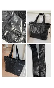 Detail view of black nylon tote bag featuring reinforced handles and embroidered logo design