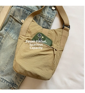Detalle del bolso bandolera de nailon caqui con bolsillo con cremallera y correa