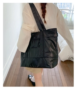 Détail du sac cabas noir en nylon avec texture matelassée et lettrage cursif brodé
