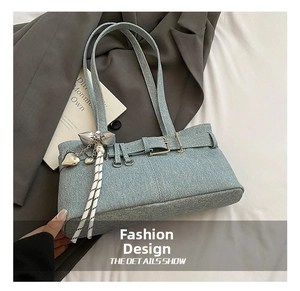 Close-up of light blue denim bucket bag with silver heart charm and bow details